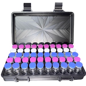 May include: An open black case filled with small glass vials. The vials have colored caps in pink, white, and blue. The case has a textured interior and a latch closure. The case is designed to hold multiple vials.