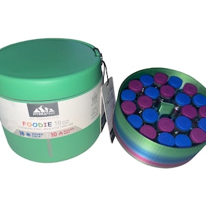 May include: A mint green Hydrapeak Foodie 18 oz stainless steel insulated food jar with a lid and a tag. Beside it is a circular container filled with numerous small vials featuring alternating blue and purple caps, arranged in a grid pattern.