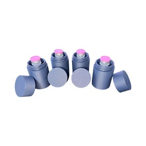 May include: Four dark blue ink blending tools with pink tops and gray sponge applicators. The tools are cylindrical with removable caps and sponges. One cap is off, revealing the sponge.