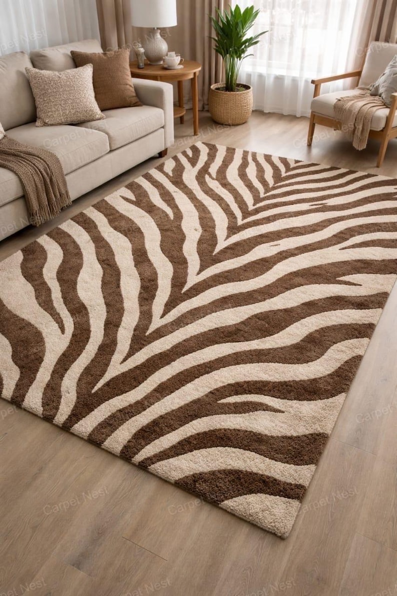 May include: A rectangular rug featuring a zebra stripe design in brown and beige. The rug's pattern consists of curved stripes, and it is placed on a wooden floor. The rug is a decorative item.