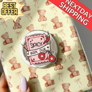 May include: A phone grip with a pink design, the words "Spicy Book Club", and a chilli pepper illustration. The phone case has a pattern of teddy bears and bows. The image also includes a "Best Offer" and "Next Day Shipping" banner.