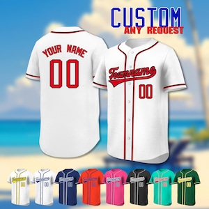 May include: White baseball jersey with red accents, featuring "Your Name" and the number "00" on the back. The front displays "Teamname" and "00". The image also shows various color options, including gold, white, navy, orange, pink, black, teal, and green jerseys. Text reads "CUSTOM ANY REQUEST".