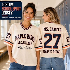 May include: A cream-colored mesh jersey featuring navy blue and orange trim on the V-neck and sleeves. The front displays 'MAPLE RIDGE ACADEMY' and 'Ms. Carter' in navy blue text, with the number '27' on the sleeves. The back shows 'MS. CARTER', '27', and 'MAPLE RIDGE'.