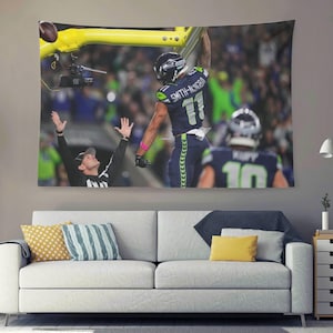 May include: A tapestry featuring a football player in a navy blue and green uniform celebrating a touchdown. The player is reaching for the goalpost, with a referee signaling a score. The background shows a stadium filled with spectators.