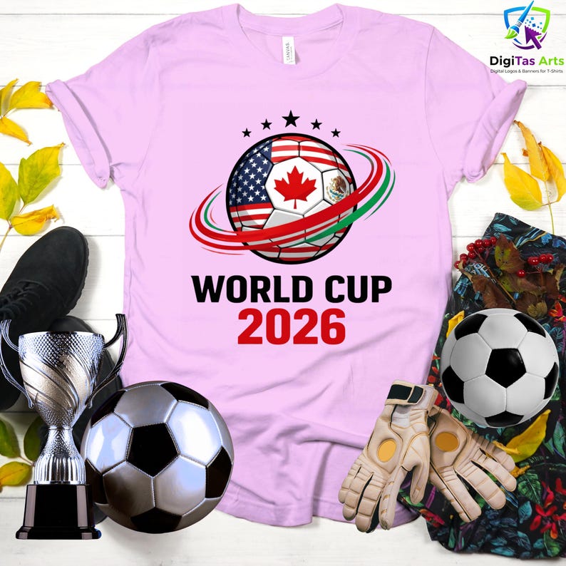 Może przedstawiać: Jasnor&oacute;żowa koszulka z motywem piłki nożnej z flagami USA, Kanady i Meksyku. Tekst "WORLD CUP 2026" jest wydrukowany poniżej. Widoczne są r&oacute;wnież inne przedmioty związane z piłką nożną.