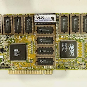 Op de afbeelding: Een groene en gouden printplaat met meerdere chips en componenten. De printplaat heeft de tekst "MX GUI BIOS Copyright" en "TMUO". Het heeft een connector aan de linkerkant en een goudkleurige randconnector.