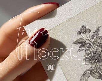 May include: Frame Mockup text over a hand holding a piece of paper with a floral illustration. The hand has red nail polish. The paper has a textured surface and a vintage aesthetic.