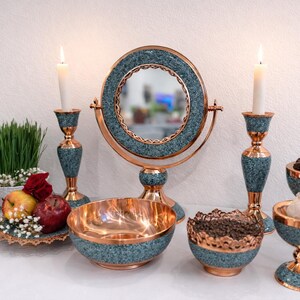 May include: A set of three ceramic nesting bowls in shades of blue, green, and white. The bowls feature a speckled glaze and a simple, modern design. The largest bowl measures approximately 6 inches in diameter.