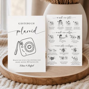 Könnte beinhalten: Zwei weiße, rechteckige Hinweiskarten mit schwarzem Text und Strichzeichnungen. Die linke Karte zeigt eine Kamera und den Text GÄSTEBUCH polaroid. Die rechte Karte enthält eine schrittweise visuelle Anleitung zum Fotografieren, für Selfies und zum Filmeinlegen.