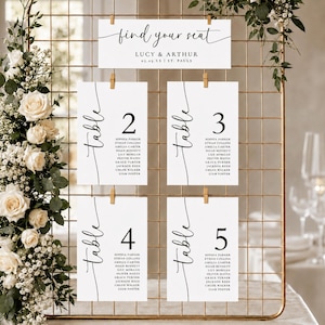 May include: A gold wire grid display holding white seating chart cards with black text. The top card reads find your seat, Lucy & Arthur, 03.09.XX, St. Pauls. Four cards below list tables 2, 3, 4, and 5 with guest names in a minimalist black font.