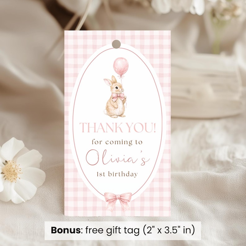 Op de afbeelding: Roze gingham cadeaulabel met een ovaal ontwerp met een aquarel illustratie van een konijn met een ballon. Tekst luidt: "THANK YOU! for coming to Olivia's 1st birthday." Inclusief een strik. Label afmetingen: 5,08 cm x 8,89 cm.