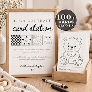 Peut inclure: Un panneau de station de cartes à haut contraste dans un cadre en bois avec du texte et des illustrations d'un damier, d'une étoile, de cercles et d'une grenouille. Un support en bois contient des cartes blanches avec un ours en peluche.