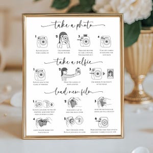 May include: A gold-framed print providing instructions for using an instant camera. The text details steps for taking photos, selfies, and loading film. The print is in black and white.