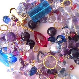 May include: A multi-strand bracelet featuring a variety of gemstones, including amethyst, sapphire, ruby, and topaz. The bracelet is made with gold wire and has a clasp closure.