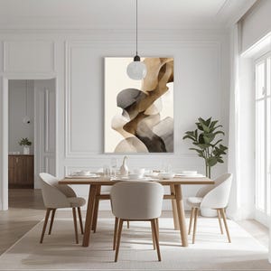 Könnte beinhalten: Ein abstrakter Kunstdruck mit fließenden Formen in Braun-, Grau- und Beigetönen hängt über einem Esstisch aus Holz. Der Raum hat eine neutrale Farbpalette mit weißen Wänden, einem hellen Teppich und modernen Stühlen.