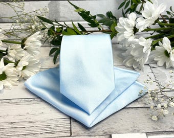 Acessórios de casamento em cetim azul claro: gravatas, laços, gravatas borboleta e abotoaduras combinando.