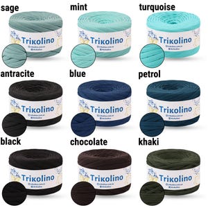 May include: Nine skeins of Trikolino yarn in various colors, including sage, mint, turquoise, anthracite, blue, petrol, black, chocolate, and khaki. Each skein is cylindrical with a label and a color swatch.