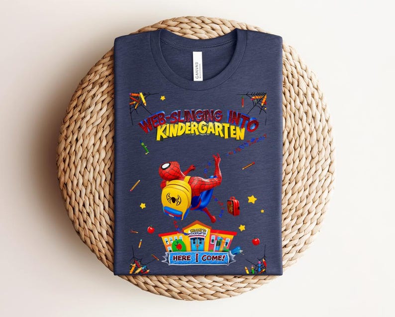 Pu&ograve; includere: T-shirt blu navy con Spider-Man, zaino, la scritta "WEB-SLINGING INTO KINDERGARTEN" e "HERE I COME!". Il design include stelle, matite e un edificio scolastico.