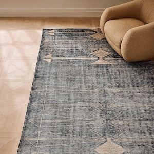 Könnte beinhalten: Ein rechteckiger Teppich mit einer dunkel marineblauen Basis und einer abgenutzten, verwitterten Textur. Der Teppich zeigt ein sich wiederholendes geometrisches Muster aus hellbeigen, länglichen Rautenformen und dünnen vertikalen Linien.