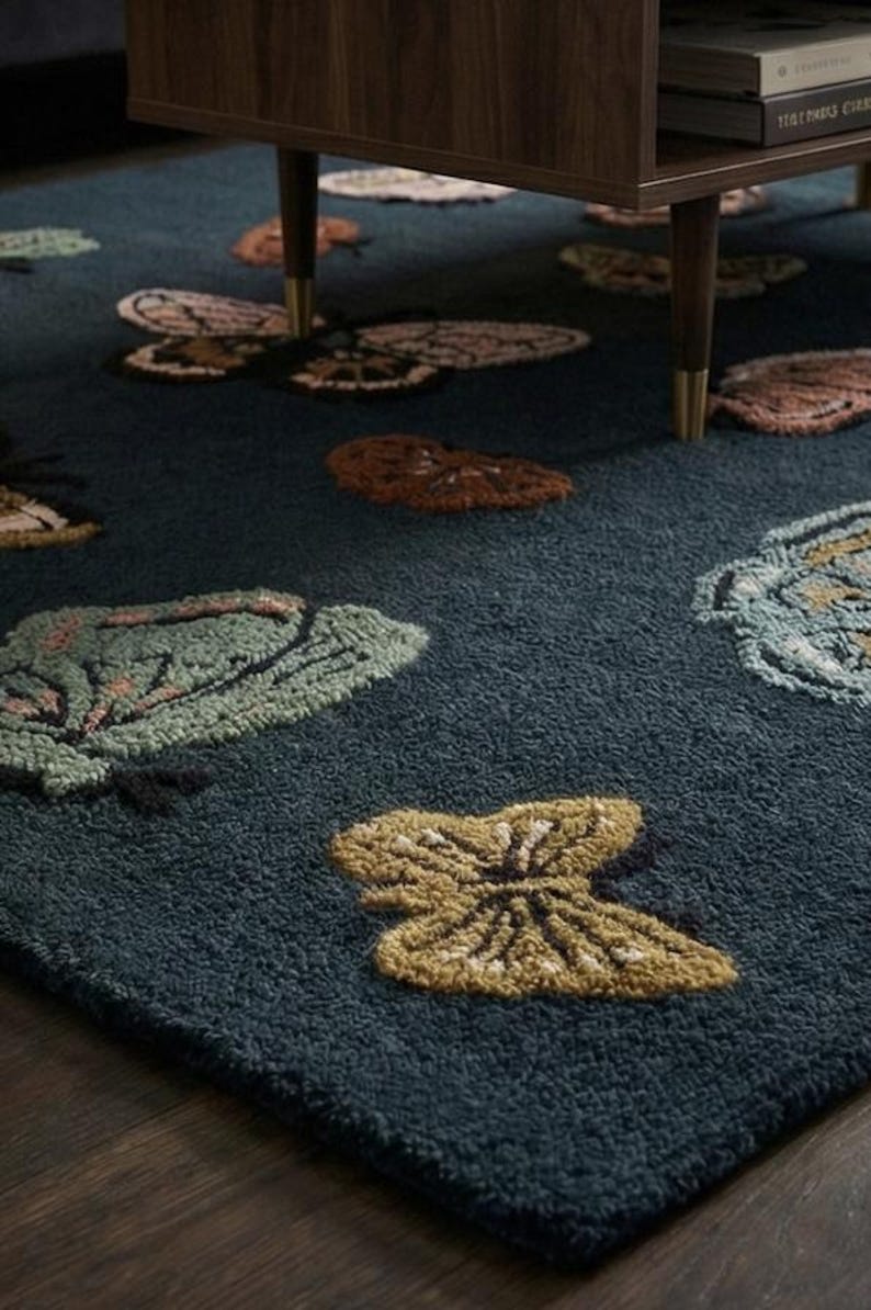 May include: A dark teal rug with a repeating butterfly pattern in shades of brown, green, and yellow. The butterflies are scattered across the rug's surface, creating a whimsical and nature-inspired design. The rug is made of a soft, textured material.