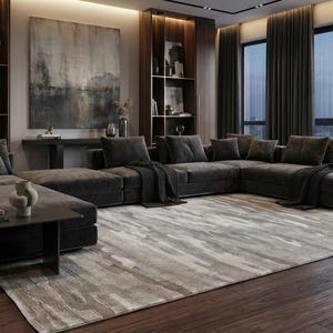May include: A contemporary living room with a large dark grey sectional sofa, a patterned rug, and dark wood flooring. The room includes built-in shelving, a large abstract painting, and floor-to-ceiling windows with dark curtains.