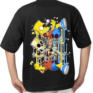 Könnte beinhalten: Schwarzes T-Shirt mit einem farbenfrohen Cartoon-Motiv eines Charakters in Skelettform mit gelben, blauen und roten Akzenten. Das Design hat einen tropfenden Farbeffekt. Ein lässiges Kleidungsstück.