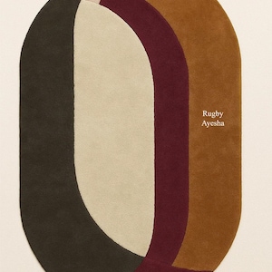 May include: Oval rug with a modern design. The rug has a colour palette of dark green, beige, burgundy, and brown. The text "Rugby Ayesha" is printed on the rug.