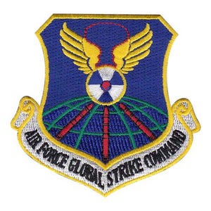 May include: Embroidered patch featuring the Air Force Global Strike Command emblem. The patch has a blue shield shape with a yellow border. The design includes yellow wings, a globe, and the text "AIR FORCE GLOBAL STRIKE COMMAND".