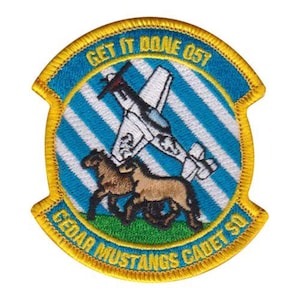May include: Embroidered patch with a blue and white striped background, featuring a white airplane and two brown horses. The patch has a yellow border with the text "GET IT DONE 057" and "CEDAR MUSTANGS CADET SQ".