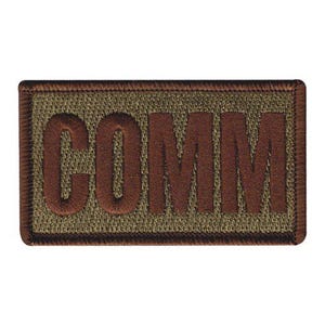 May include: A white ceramic mug with a black handle and the text "But First, Coffee" in a bold, black font. The mug is set against a blurred background, suggesting a cozy setting.