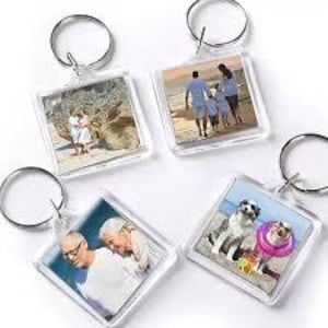 May include: Four clear acrylic square keychains with silver keyrings. Each keychain displays a different photograph: a couple, a family on a beach, an elderly couple, and two dogs. The keychains are ideal for personalized gifts.