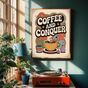 以下が含まれることがあります： 「Coffee and Conquer」の文字が入ったレトロスタイルのフレームプリント。ロケット、虹、星が描かれたコーヒーカップのアートワーク。 ターコイズの壁に飾られ、レコードプレーヤーの上に配置されています。