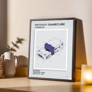 May include: Framed print featuring a detailed diagram of a Nintendo GameCube console. The artwork showcases the console's components in a technical illustration style, with a purple and white color scheme. Text at the top reads "NINTENDO GAMECUBE CONSOLE".
