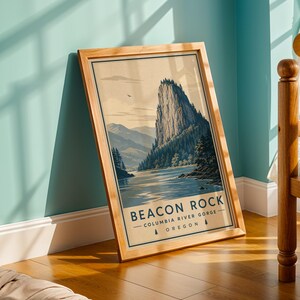 May include: A framed vertical art print featuring a landscape illustration of Beacon Rock in the Columbia River Gorge, Oregon. The print displays a large rock formation, a river, and evergreen trees with the text BEACON ROCK COLUMBIA RIVER GORGE OREGON.