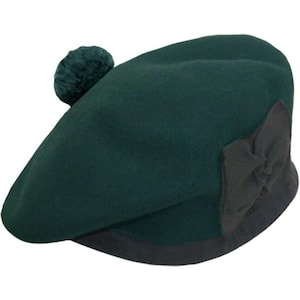 May include: A dark green beret with a black bow and a small, dark green pom-pom. The beret is made of a soft material and has a classic, rounded shape. The bow is attached to the side of the beret.