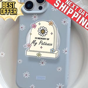 May include: A light blue phone case with a daisy pattern and a clear pop socket. The pop socket has a tombstone design with the text "IN MEMORY OF My Patience". The case also has the text "Bonne Case" and a "BEST OFFER" sticker.