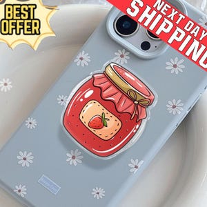 May include: A light blue phone case with a daisy pattern and a clear, cartoon-style strawberry jam jar sticker. The sticker has a red jar with a gold lid and a strawberry label. The words "Best Offer" and "Next Day Shipping" are also visible.