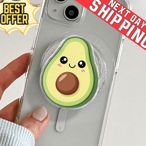 May include: Clear phone case featuring a cartoon avocado design. The avocado has a smiling face, a brown pit, and green and yellow details. The case also has a pop-up grip. The words "BEST OFFER" are in a yellow banner.