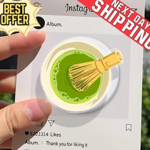 May include: A clear, round phone grip featuring a matcha bowl with a bamboo whisk. The design is set against a white background with a social media interface, including the text "Album" and "520.1314 Likes". A "Best Offer" and "Next Day Shipping" banner are also visible.