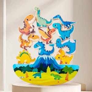 May include: A wooden dinosaur balancing game with colourful dinosaur figures in orange, blue, yellow, and green. The base is a yellow and green landscape with palm trees and a volcano. The dinosaurs are stacked on top of the volcano.