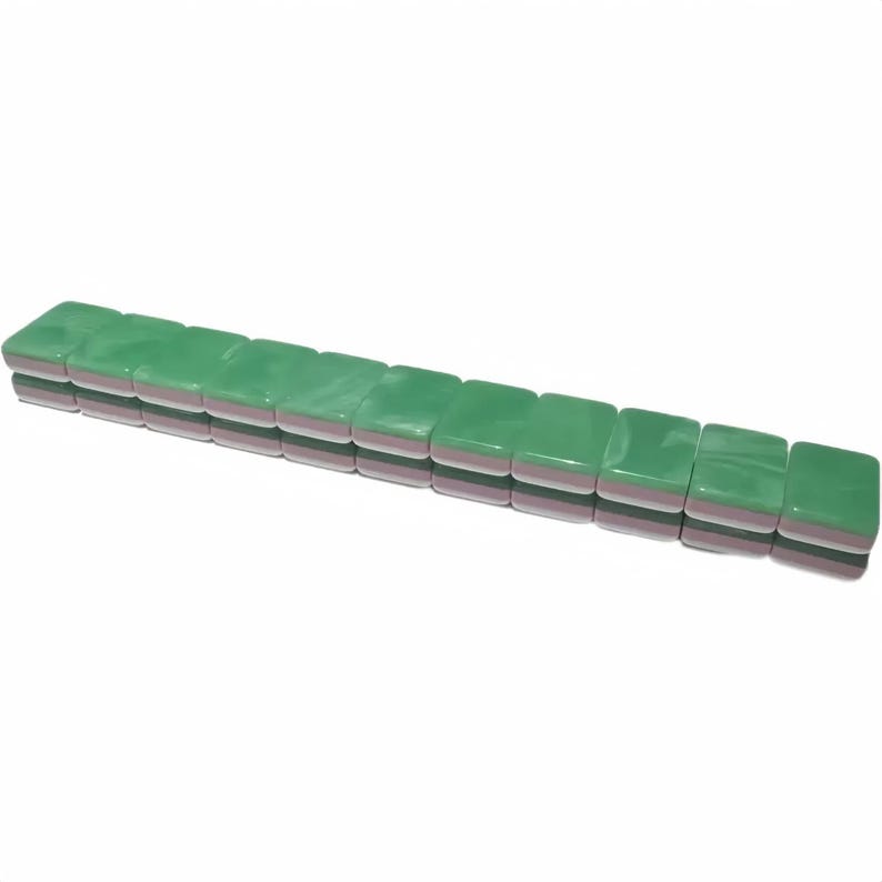 May include: A row of green Mahjong tiles. Each tile is rectangular with rounded corners, a glossy green top, and a pink and white layered side. The tiles are stacked in a neat row, suggesting a game in progress.