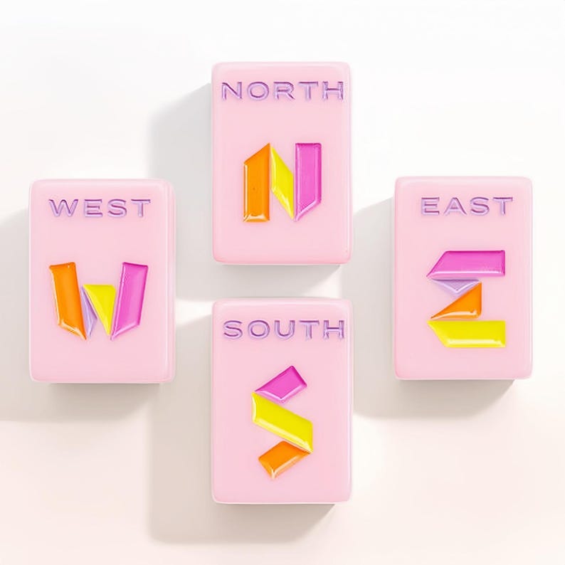 May include: Four rectangular light pink tiles arranged in a compass formation. Each tile features a cardinal direction label in purple text and a stylized letter icon in orange, yellow, and magenta. The tiles are labeled NORTH, SOUTH, EAST, and WEST.