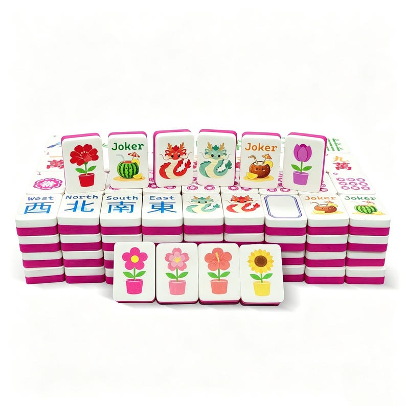 May include: A set of colorful Mahjong tiles with pink edges and various illustrations. The tiles feature images of flowers, fruits, and dragons. Some tiles have the word "Joker" printed on them. The set includes tiles with Chinese characters.