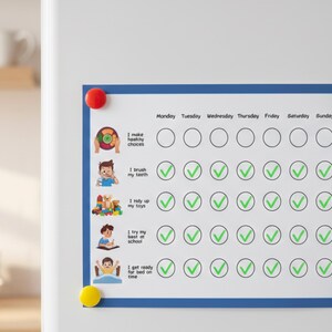 May include: A white chore chart with a blue border is attached to a white surface with colorful magnets. The chart has illustrations and text for daily tasks like brushing teeth and making healthy choices. Check marks indicate completed tasks.