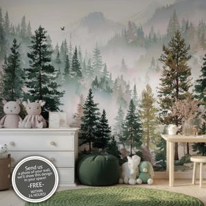 May include: A whimsical nursery scene featuring a forest mural with green and brown trees. A white dresser, a small table, and a green beanbag chair are in front of the mural. Soft toys and decorative items complete the room's decor. The text on the image says "Send us a photo of your wall, we'll show this design in your space! -FREE- WITHIN 24 HOURS!"