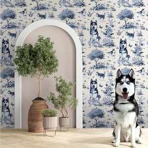 May include: A Siberian Husky dog with blue eyes sits in front of a wall with a blue and white toile pattern featuring dogs, trees, and butterflies. The room has potted plants and an arched doorway.