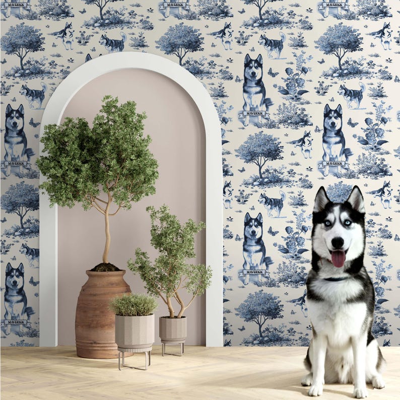 May include: A Siberian Husky dog with blue eyes sits in front of a wall with a blue and white toile pattern featuring dogs, trees, and butterflies. The room has potted plants and an arched doorway.
