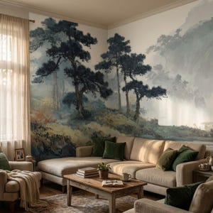 May include: A living room with a large, beige sectional sofa, green throw pillows, and a wooden coffee table. The focal point is a mural of a misty forest scene with dark green trees and a muted color palette. The room has a cozy and inviting atmosphere.