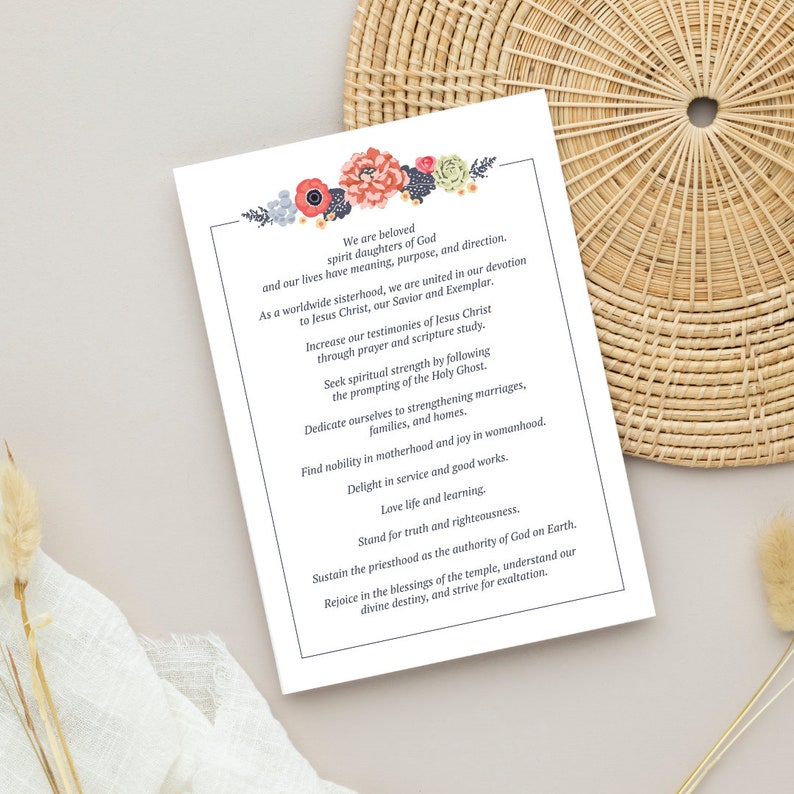 May include: A white card with a floral design at the top and text that reads "We are beloved spirit daughters of God and our lives have meaning, purpose, and direction. As a worldwide sisterhood, we are united in our devotion to Jesus Christ, our Savior and Exemplar. Increase our testimonies of Jesus Christ through prayer and scripture study. Seek spiritual strength by following the promptings of the Holy Ghost. Dedicate ourselves to strengthening marriages, families, and homes. Find nobility in motherhood and joy in womanhood. Delight in service and good works. Love life and learning. Stand for truth and righteousness. Sustain the priesthood as the authority of God on Earth. Rejoice in the blessings of the temple, understand our divine destiny, and strive for exaltation."