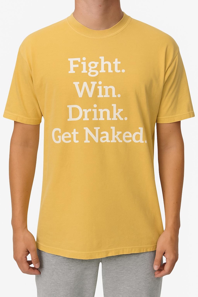 K&ouml;nnte beinhalten: Senfgelbes T-Shirt mit dem wei&szlig;en Aufdruck "Fight. Win. Drink. Get Naked." in Blockbuchstaben. Das Shirt hat einen Rundhalsausschnitt und kurze &Auml;rmel.